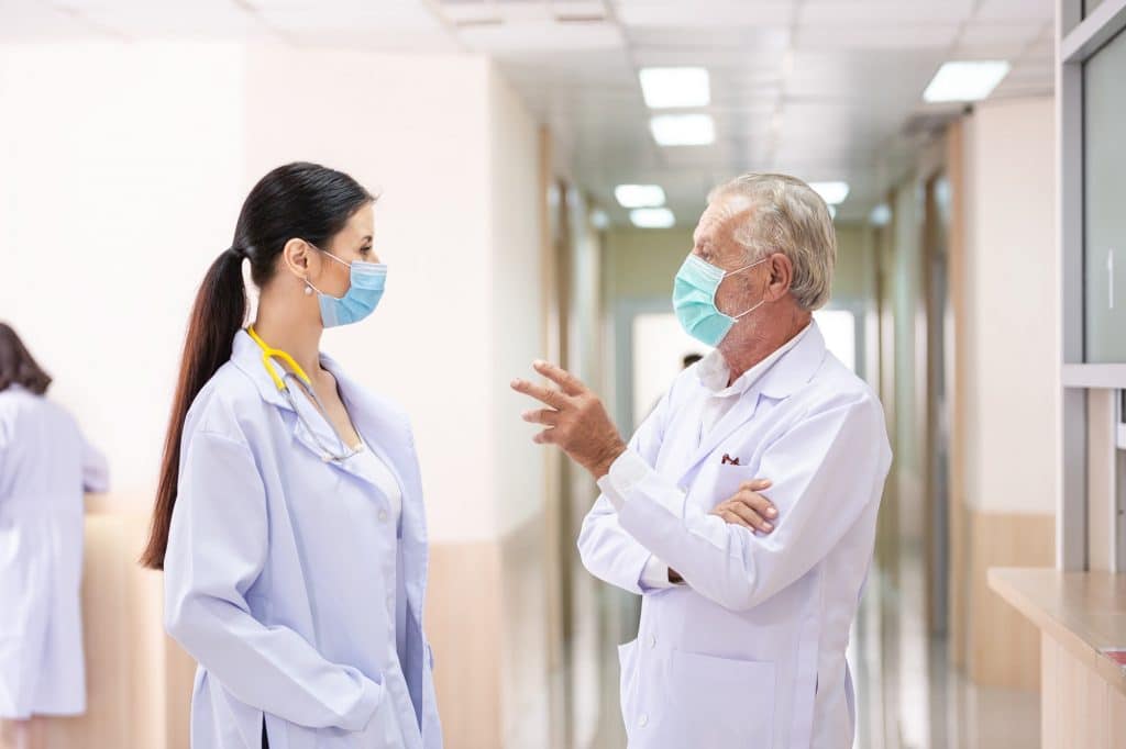 senior doctor talking with female doctor at hospital